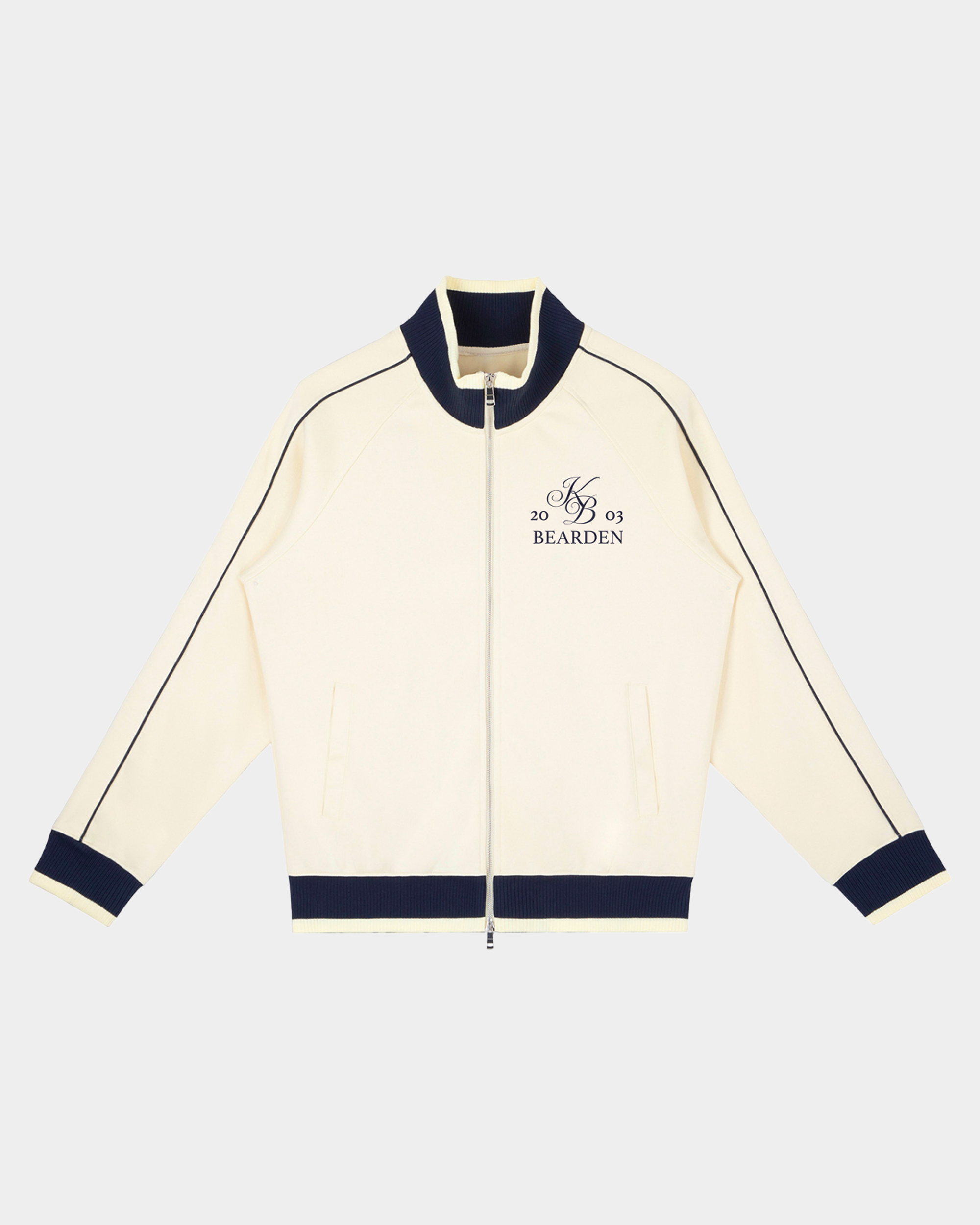 Kaleb A. Bearden Home Blues Track Jacket showing navy blue fabric with white stripe details and front zipper closure.